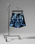 Blue tie-dye shorts on a hanger against a gray background