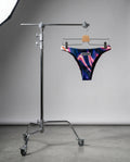 Colorful swim brief front  hanging on a stand against a gray background