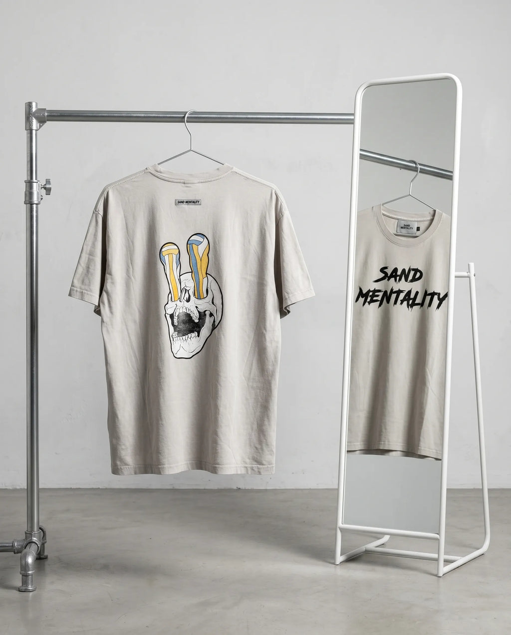Two t-shirts on hangers with graphic designs in a minimalistic setting