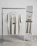 Two t-shirts on hangers with graphic designs in a minimalistic setting
