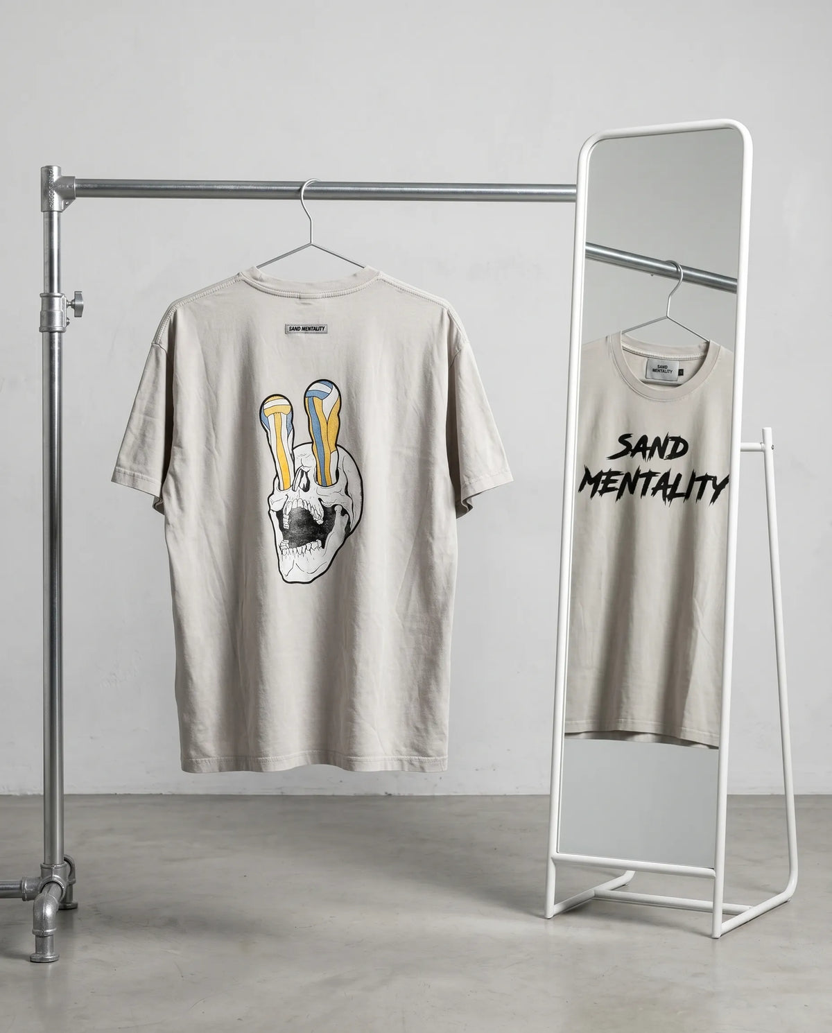Two t-shirts on hangers with graphic designs in a minimalistic setting