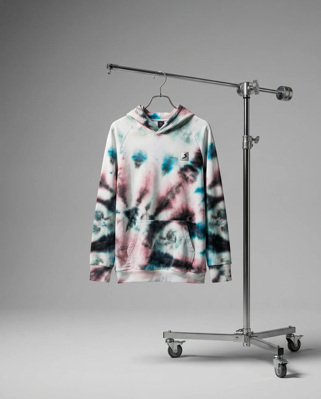 Tie-dye hoodie on a hanger attached to a metal stand against a gray background