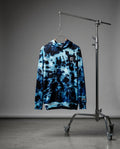 Blue tie-dye hoodie on a hanger against a gray background